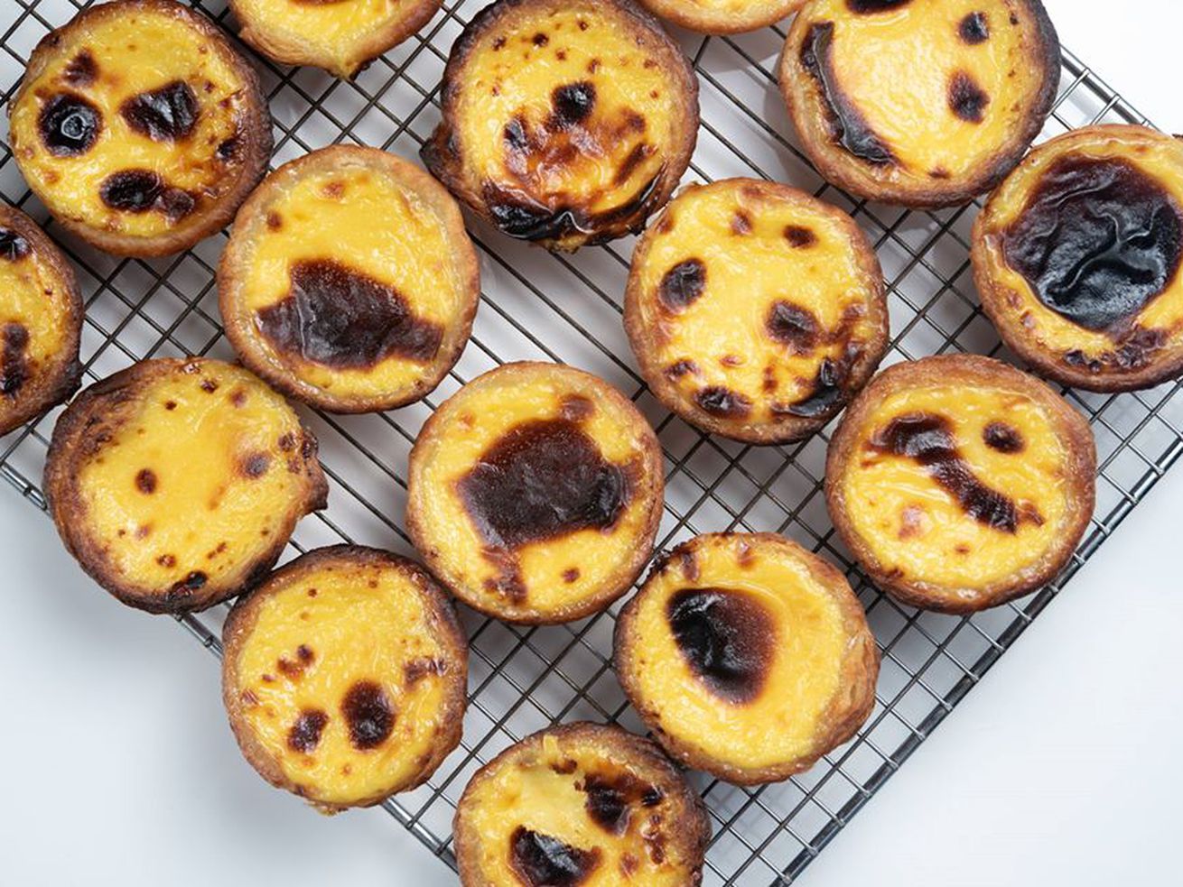 Egg tarts cooling on a wire rack